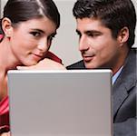 Close-up of a businessman and a businesswoman in front of a laptop