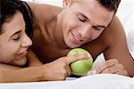 Gros plan d'un jeune couple en regardant une pomme verte