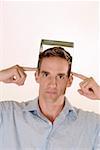 Portrait of a mid adult man holding a CD case on his head