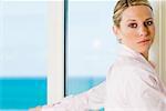 Side profile of a businesswoman standing beside a window