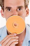 Portrait of a mid adult man holding a CD in front of his mouth