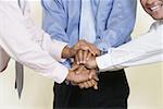 Close-up of three businessmen shaking hands