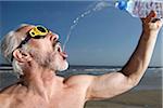 Man on Beach Drinking from Water Bottle