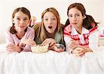 Girls Lying on Bed, Eating Popcorn