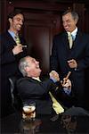 Three businessmen celebrating with cigars