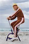 Senior adult woman riding an exercise bike