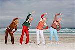 Four senior adults stretching on beach