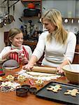 Girl and mother making cookies