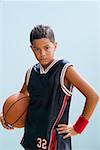 Boy in basketball uniform holding basketball