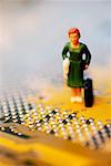Close-up of the figurine of a woman with a briefcase on a circuit board