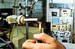 Close-up of a person's hand lighting a cigarette on a testing machine in a manufacturing plant, Richmond, Virginia, USA