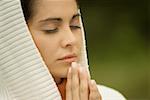 Close-up of a young woman praying with her eyes closed