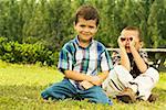 Portrait des deux garçons assis sur la pelouse