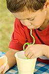 Close-up of a boy drinking with a drinking straw