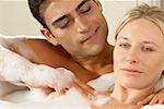 Portrait d'une jeune femme en recevant un massage d'un jeune homme dans un bain moussant