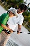 Gros plan d'un garçon tenant une canne à pêche avec son père