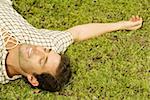 High angle view of a mid adult man sleeping on the grass