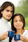 Close-up of a young couple holding coffee cups