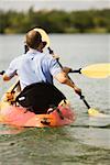 Vue arrière d'un jeune homme en kayak dans un lac