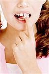 Gros plan d'une jeune fille tenant un morceau de sucre entre ses dents