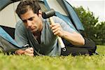 Close-up of a mid adult man putting up a tent