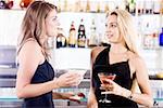 Gros plan des deux jeunes femmes tenant des verres de cocktail