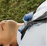 Close-up of a businessman lying on the grass