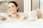 Portrait of a young woman reclining in a bubble bath