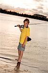 Portrait of a boy smiling carrying a fishing rod