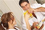 Mid adult couple toasting with glasses of juice