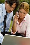 Gros plan d'un homme et une femme d'affaires travaillant sur un ordinateur portable et de parler sur un téléphone mobile
