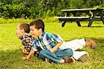 Vue grand angle de deux jeunes garçons jouant sur l'herbe