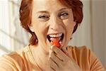Portrait of a senior Woman eine erdbeere essen