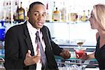 Close-up of a businessman and a young woman at a bar counter