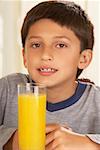 Portrait of a boy in front of a glass of juice