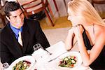 High angle view of a mid adult man and a young woman sitting at a table in a restaurant