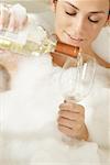 Close-up of a young woman pouring champagne in a champagne flute