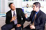 Close-up of two businessmen holding champagne flutes