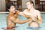 Gros plan des deux jeunes hommes wrestling dans une piscine