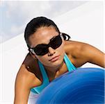 Close-up of a young woman exercising with a fitness ball