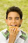 Close-up of a boy eating a burger