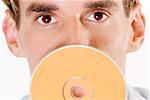 Portrait d'un jeune homme tenant un CD devant sa bouche