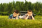 Two boys lying on the lawn