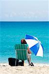 Rückansicht einer Frau sitzt auf dem Strand, South Beach, Miami, Florida, USA