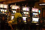 Rear view of a man sitting at a slot machine, New Orleans, Louisiana, USA
