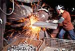 Side profile of a foundry worker working on a metal saw in a factory, Wisconsin, USA