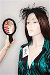 Woman Holding Mirror By Mannequin