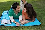 Junges Paar auf einer Decke im Park liegend