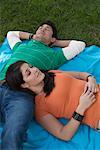 Young Couple Lying Down On Blanket in the Park