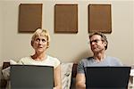 Couple Using Laptop Computers in Bed